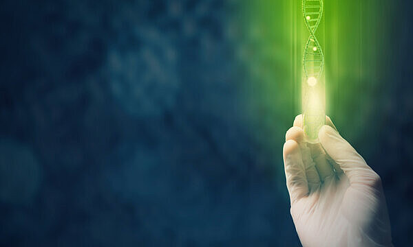 A hand holding a green light which is shape as DNA