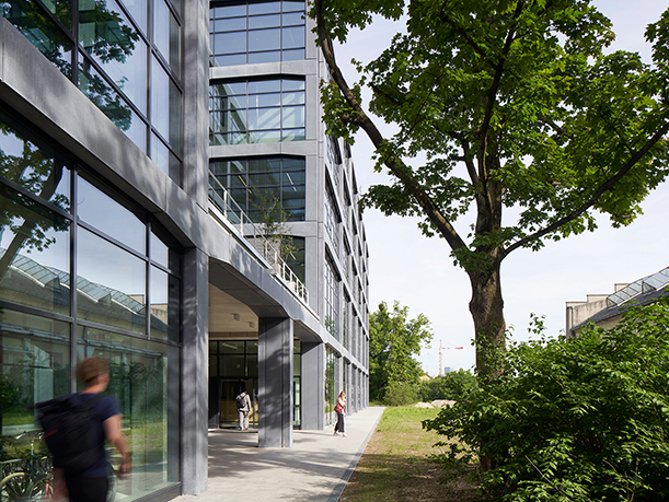 Picture of the Munich Urban Colab building, a modern grey buildng with a lot of glass.